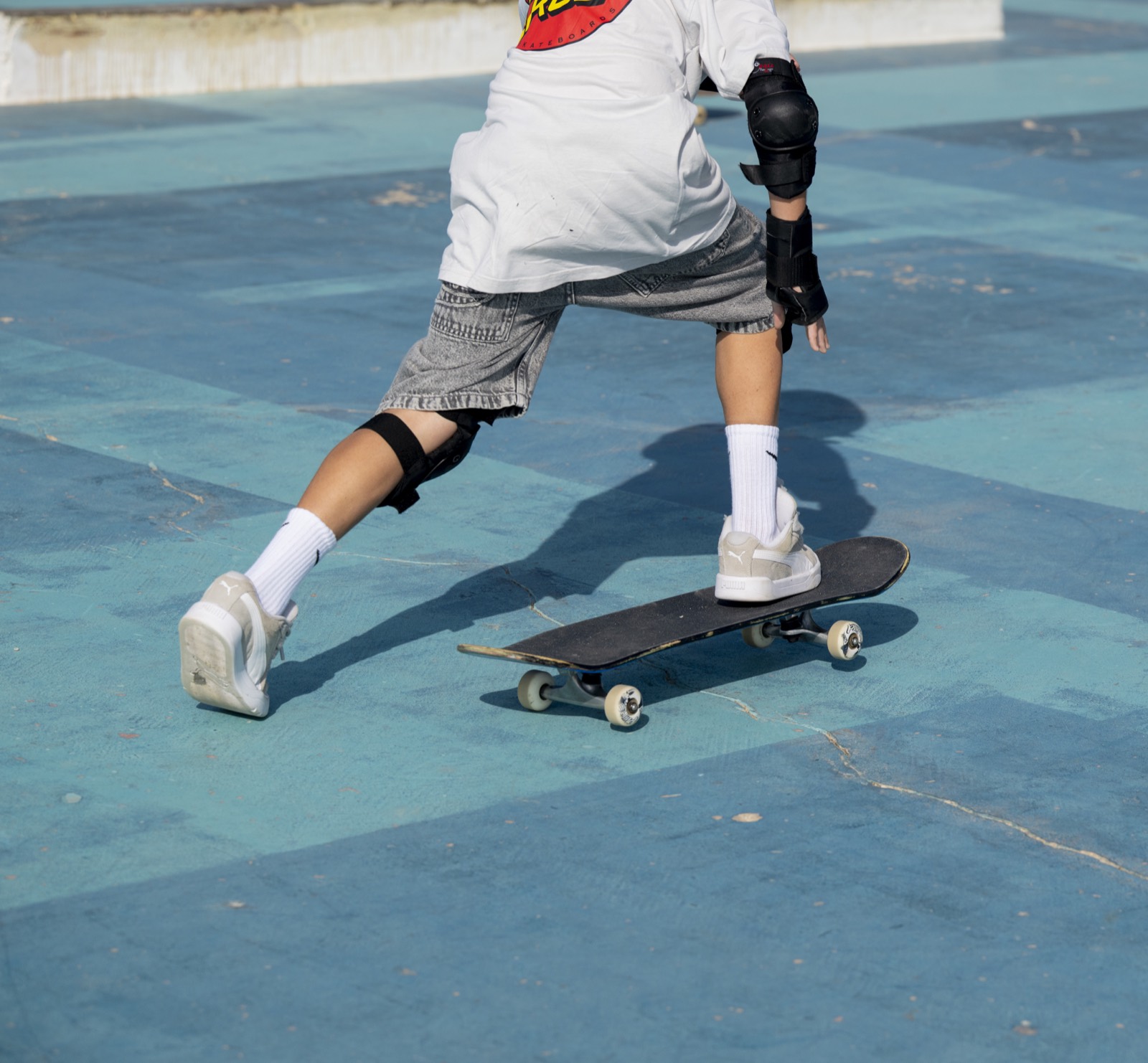 Peque impulsándose con la tabla en el skatepark